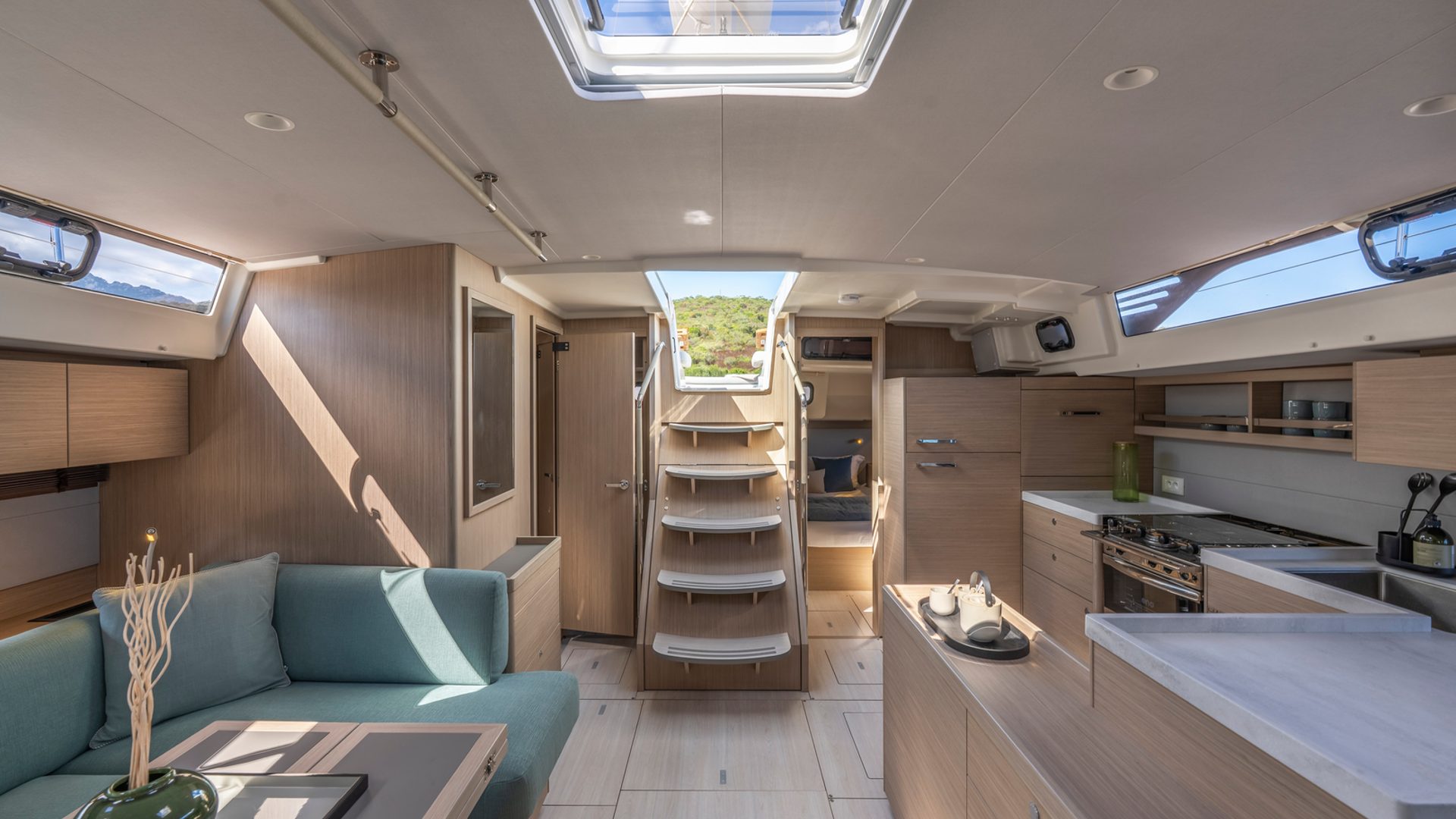Salon — light oak, skylight, full galley aft to starboard.